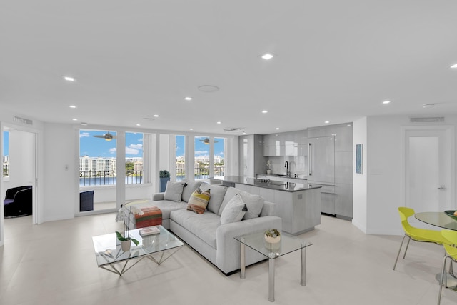 living room with baseboards, a water view, recessed lighting, and visible vents