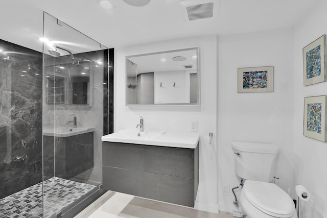 full bath with a marble finish shower, vanity, toilet, and visible vents