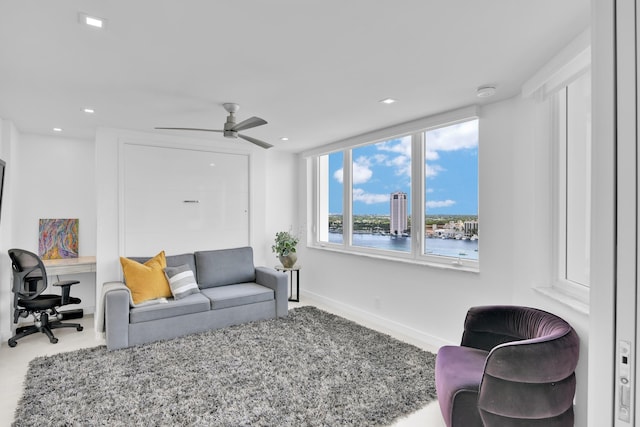 living room with a water view, a ceiling fan, recessed lighting, and baseboards