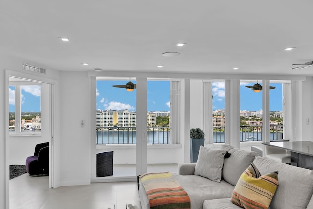 living room with a healthy amount of sunlight, ceiling fan, and visible vents