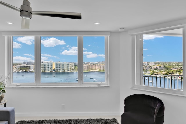 living area featuring a city view, ceiling fan, and a wealth of natural light
