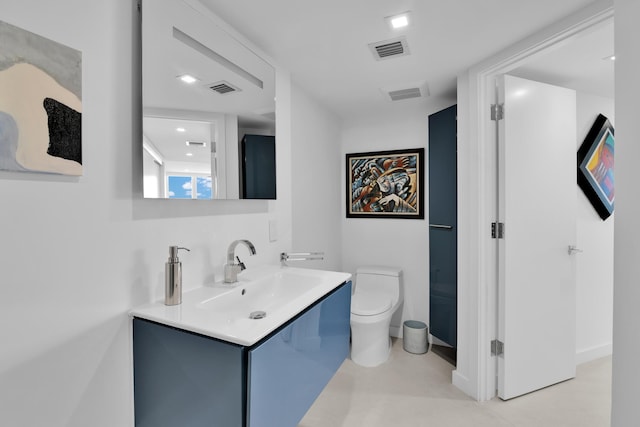 bathroom featuring vanity, toilet, and visible vents