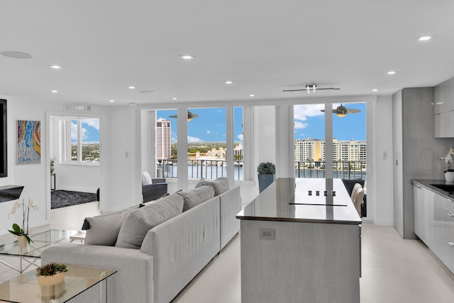 living area featuring recessed lighting, a water view, and visible vents