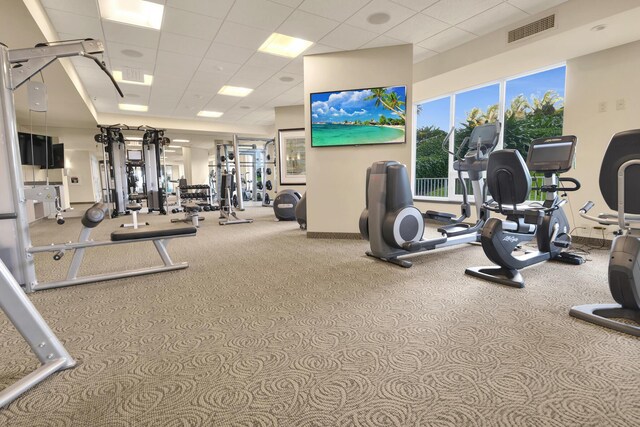 workout area featuring baseboards, carpet, a drop ceiling, and visible vents
