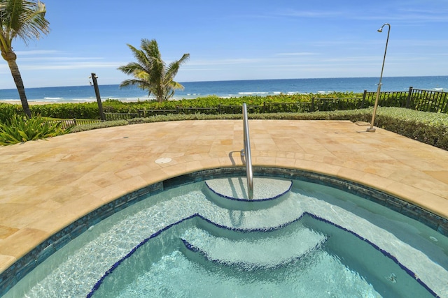 view of pool with a water view, fence, a patio, and a pool