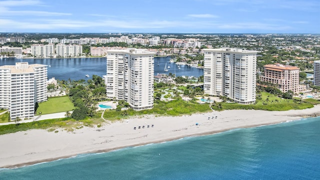 drone / aerial view featuring a water view, a view of the beach, and a view of city