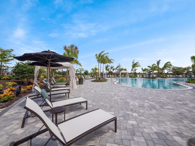 community pool featuring fence and a patio area