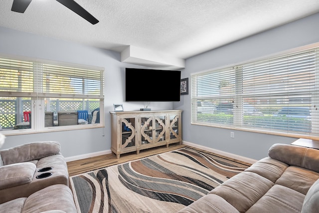 3531 SW Sunset Trace Cir, Palm City, FL 34990 - living area with a textured ceiling, a healthy amount of sunlight, baseboards, and a ceiling fan