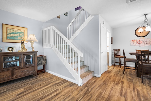3531 SW Sunset Trace Cir, Palm City, FL 34990 - stairway with a textured ceiling, wood finished floors, and baseboards