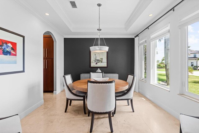 dining room featuring baseboards, visible vents, arched walkways, and ornamental molding