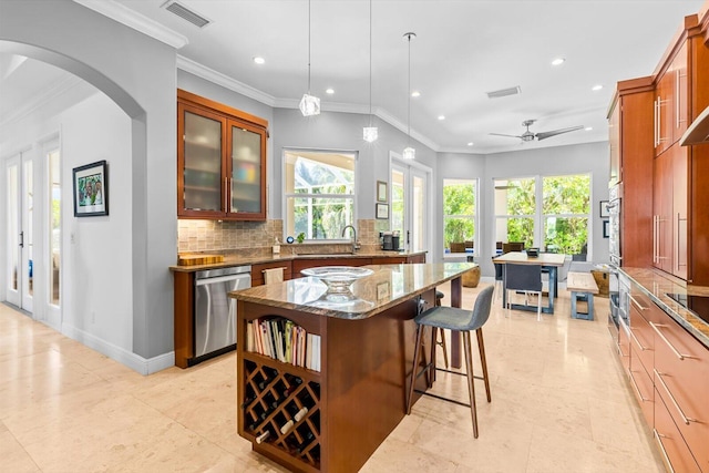 kitchen featuring dark stone counters, decorative backsplash, appliances with stainless steel finishes, a kitchen island, and recessed lighting