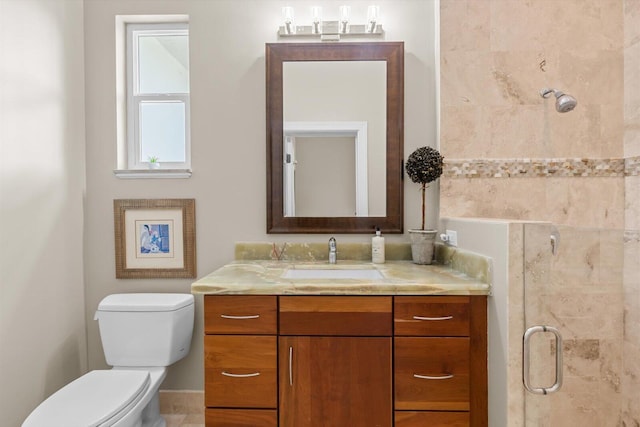 bathroom featuring tiled shower, toilet, and vanity