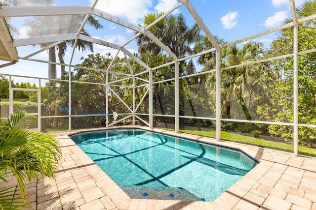 outdoor pool featuring glass enclosure and a patio area