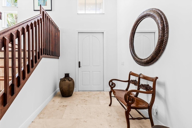 interior space featuring a high ceiling and baseboards