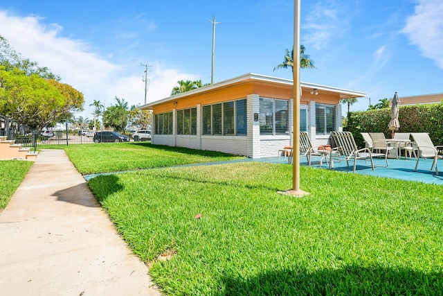 31 S Golfview Rd # 11, Lake Worth Beach, FL 33460 - rear view of property featuring a yard, brick siding, fence, and a patio area