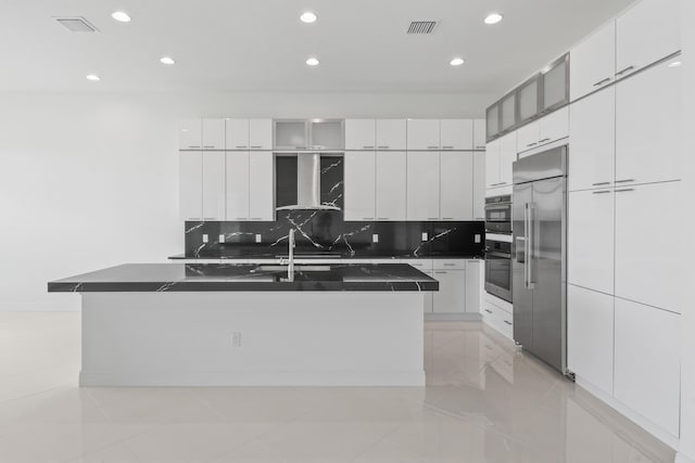 kitchen featuring appliances with stainless steel finishes, dark countertops, recessed lighting, wall chimney exhaust hood, and modern cabinets