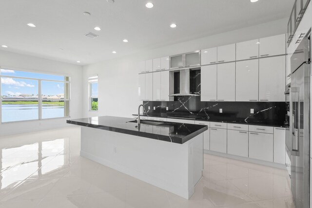 kitchen with tasteful backsplash, a sink, dark countertops, recessed lighting, and wall chimney exhaust hood
