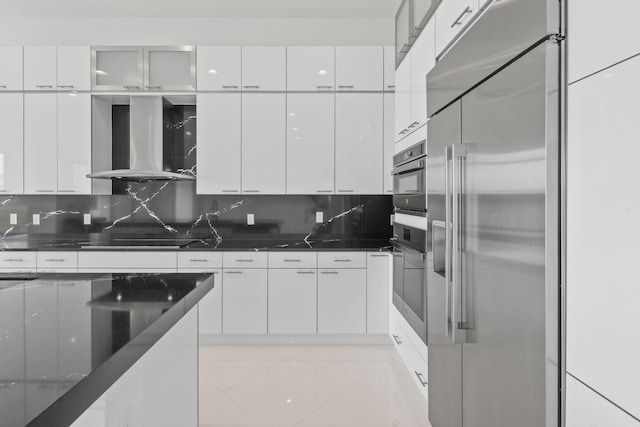 kitchen featuring appliances with stainless steel finishes, wall chimney range hood, white cabinets, backsplash, and modern cabinets