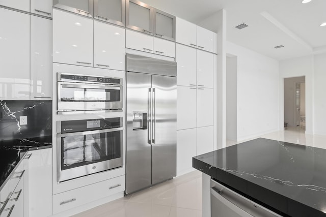 kitchen featuring appliances with stainless steel finishes, white cabinetry, visible vents, light tile patterned flooring, and modern cabinets