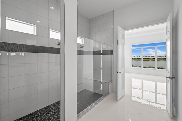 full bath featuring tile patterned flooring, a water view, and a walk in shower