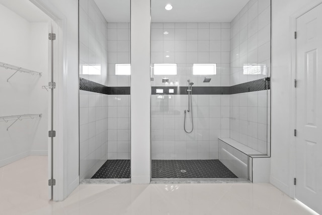 bathroom with tile patterned floors, a spacious closet, a shower stall, and recessed lighting