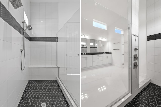 bathroom featuring a tile shower, tile patterned flooring, and vanity