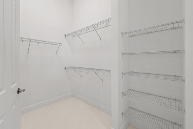 walk in closet with tile patterned flooring