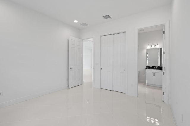 unfurnished bedroom with light tile patterned floors, visible vents, baseboards, a closet, and recessed lighting