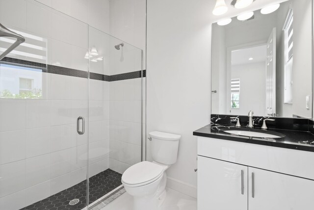 full bathroom with toilet, a shower stall, vanity, and baseboards