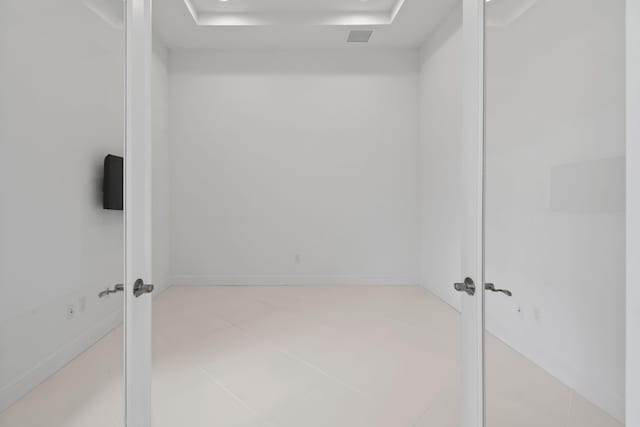 empty room with baseboards, visible vents, and light tile patterned floors