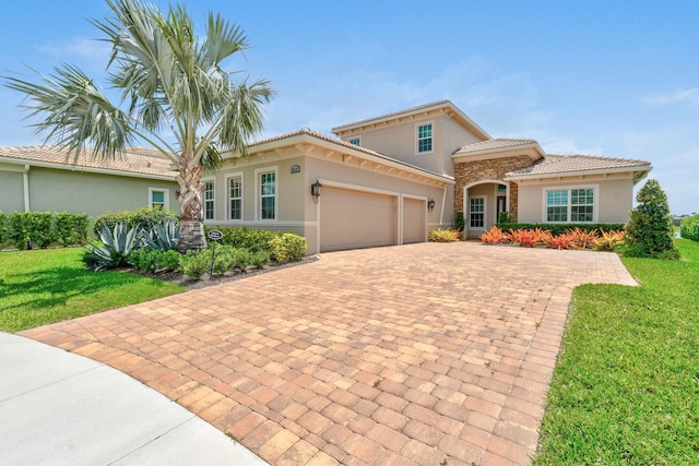 mediterranean / spanish-style house with a garage, a front lawn, stucco siding, and decorative driveway