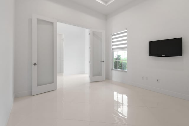 unfurnished room featuring tile patterned floors and baseboards