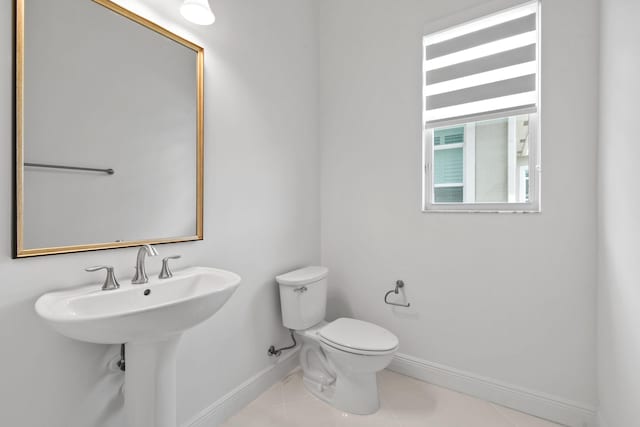 bathroom with tile patterned floors, a sink, toilet, and baseboards