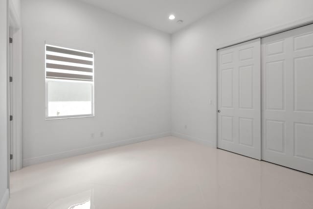 unfurnished bedroom with baseboards, recessed lighting, and a closet