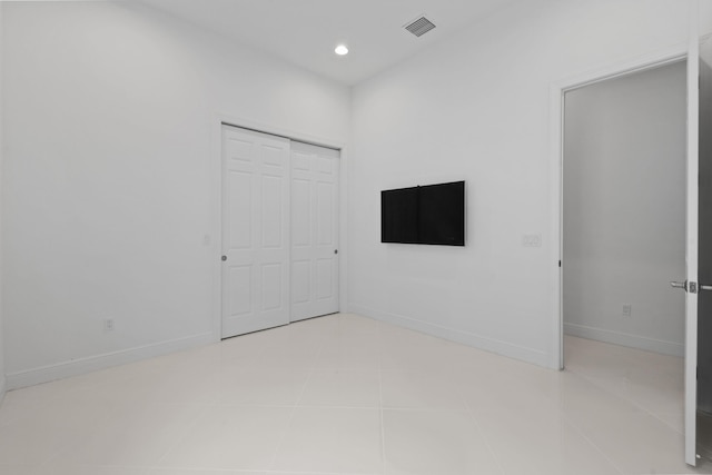 unfurnished bedroom with recessed lighting, a closet, tile patterned floors, visible vents, and baseboards