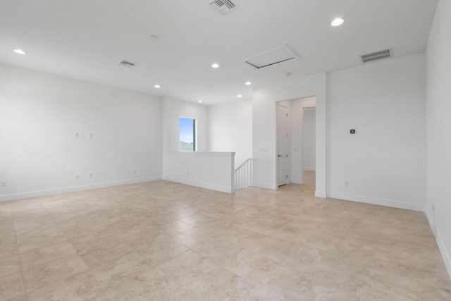empty room featuring baseboards, visible vents, attic access, and recessed lighting