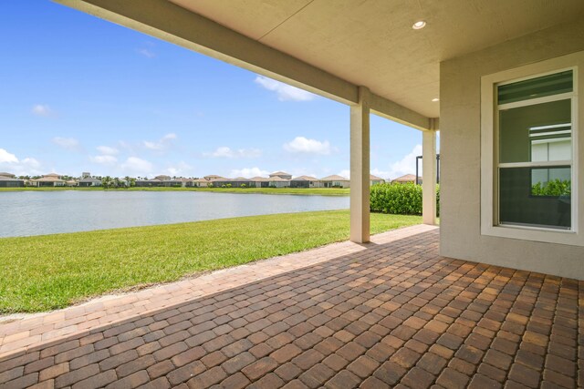 view of patio with a residential view and a water view