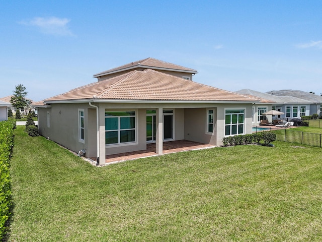 rear view of house with stucco siding, fence, a patio, and a tile roof