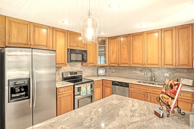 20 Lexington Ln W Unit B, Palm Beach Gardens, FL 33418 - kitchen featuring appliances with stainless steel finishes, a sink, light stone countertops, and brown cabinetry