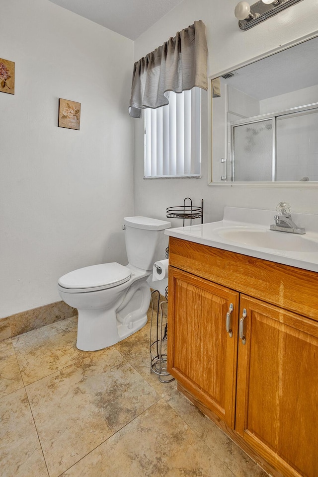 bathroom featuring a shower stall, vanity, and toilet