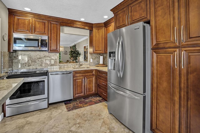 kitchen with tasteful backsplash, recessed lighting, crown molding, appliances with stainless steel finishes, and a sink