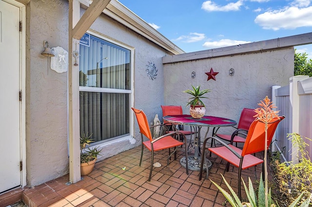 view of patio with outdoor dining area and fence