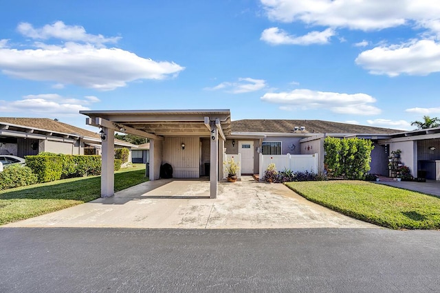 view of front of property with a carport, a front yard, and fence