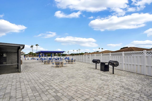 view of patio with a grill and fence