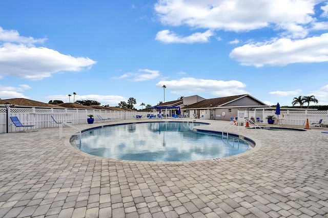 community pool featuring a patio area and fence