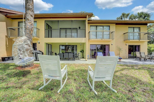 5337 Fountains Dr S, Lake Worth, FL 33467 - back of house featuring stucco siding, a balcony, a patio, and a lawn