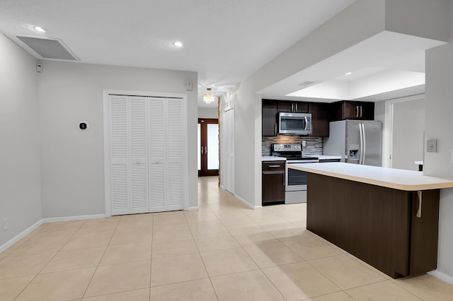 kitchen with stainless steel appliances, light tile patterned flooring, baseboards, backsplash, and light countertops