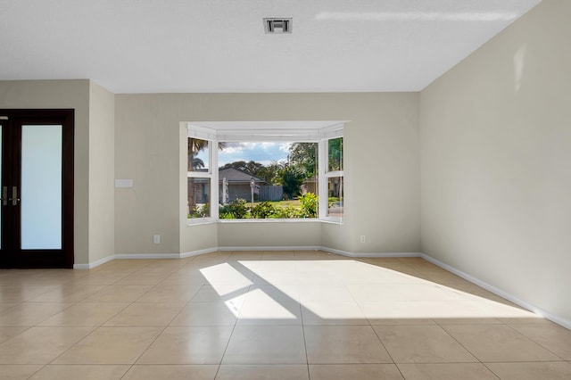 spare room featuring visible vents, tile patterned floors, and baseboards