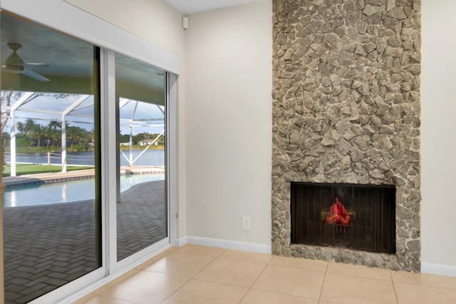 interior space with a sunroom, a ceiling fan, baseboards, and tile patterned floors