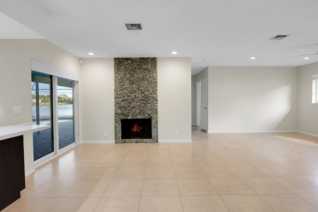 unfurnished living room featuring a fireplace, visible vents, and a wealth of natural light